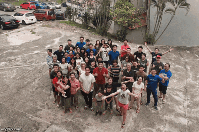 a large group of people posing for a picture with one wearing a shirt that says ' a ' on it