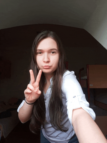 a girl giving a peace sign with her fingers