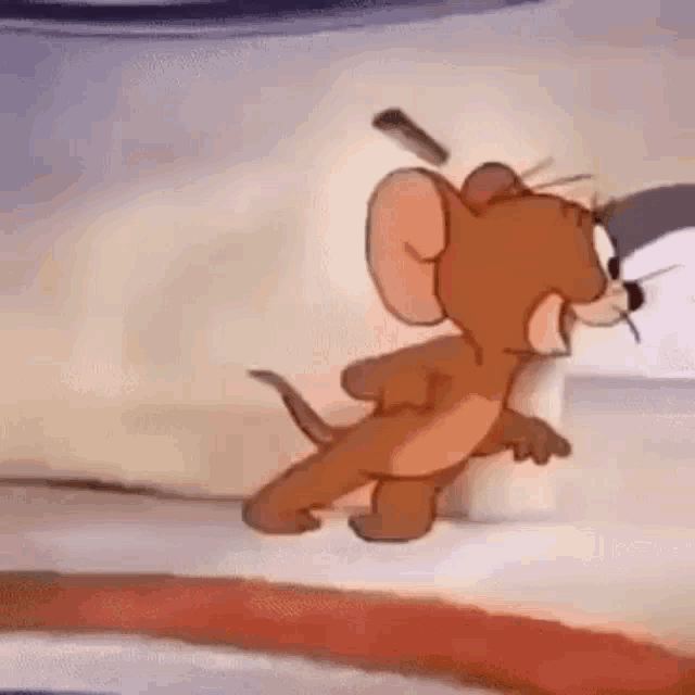 a cartoon mouse is running away from a cat in a room .
