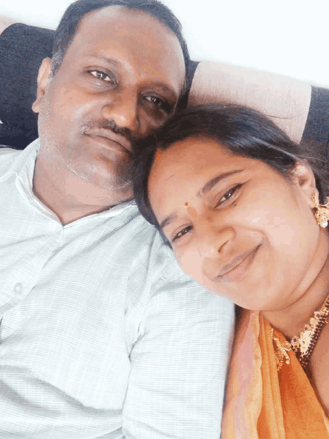 a man and a woman are posing for a picture and the woman is smiling