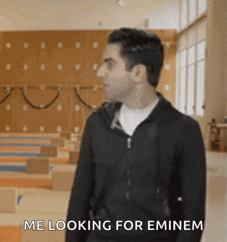 a man standing in a gym with the words me looking for eminem written below him