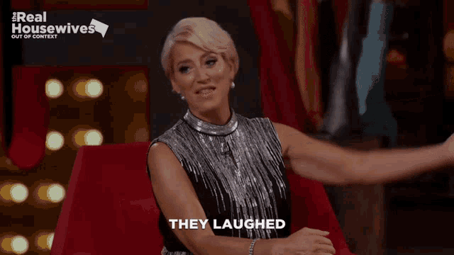 a woman is sitting on a red couch with her arms outstretched and the words they laughed above her