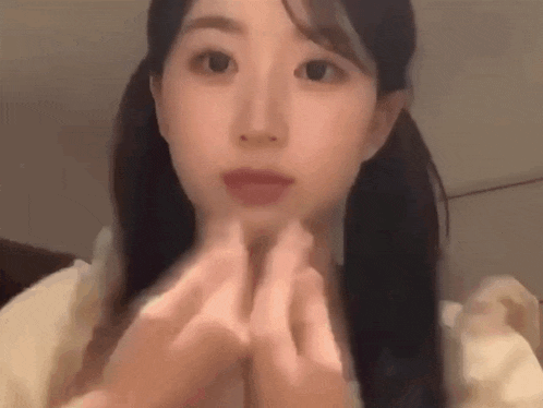 a young woman is making a heart shape with her hands .