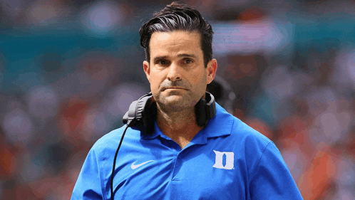 a man wearing a blue shirt with duke on it