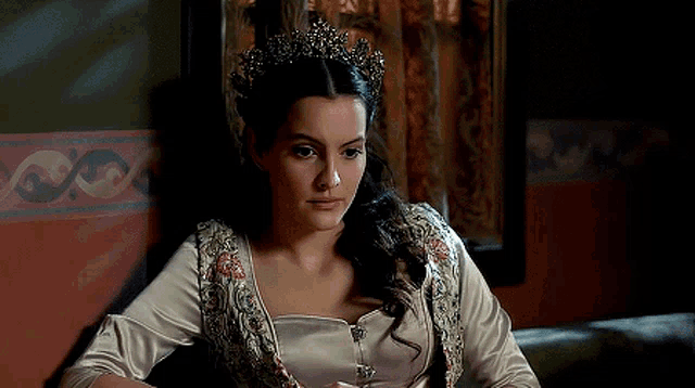 a woman wearing a tiara is sitting in a chair