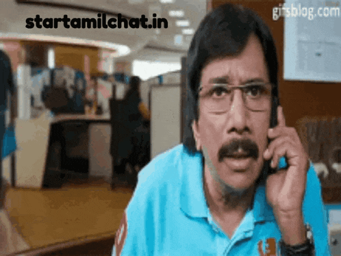 a man with glasses and a mustache talking on a cell phone