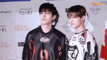 two young men standing next to each other in front of a wall that says juice and grocery