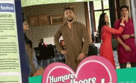 a man in a brown kurta stands next to a woman in a red dress in front of a sign that says humare thoore
