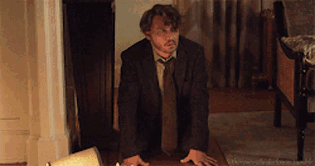 a man in a suit and tie is standing on a table