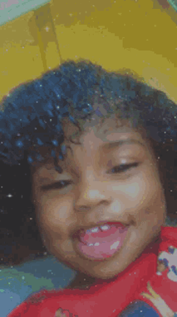 a little girl with her eyes closed and her tongue out .
