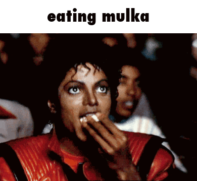 a man in a red leather jacket is eating a mukkah