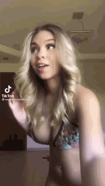 a woman in a bikini is making a funny face in a tik tok video .