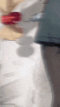 a blurry picture of a person standing in front of a white wall .