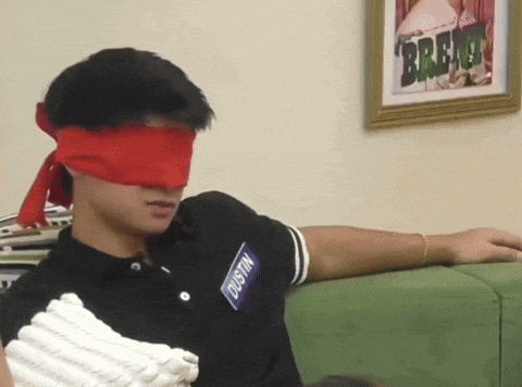 a blindfolded dustin sitting on a couch