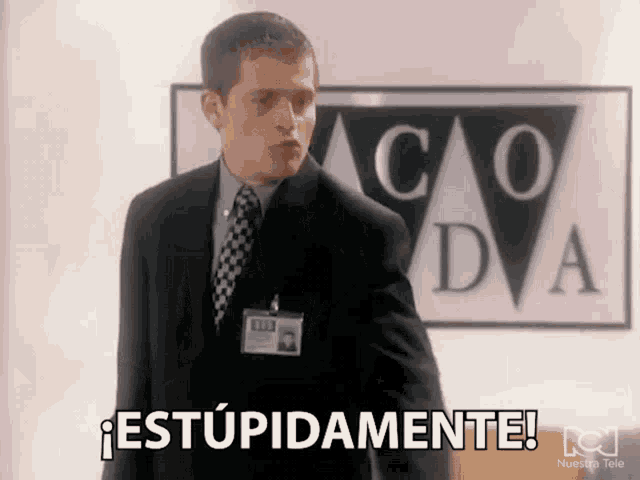 a man in a suit and tie is standing in front of a sign that says co dva