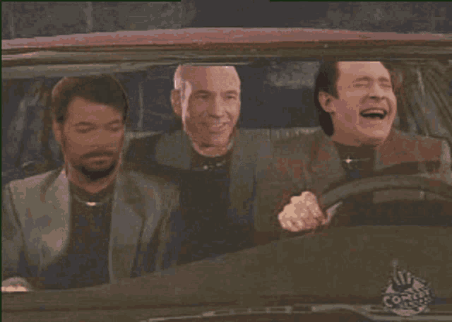 three men are laughing in a car with a comedy central logo