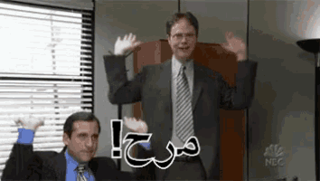 a man in a suit and tie is waving his arms in the air while another man looks on .