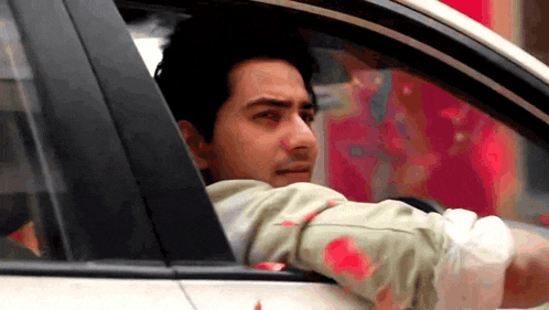 a man driving a car with blood on his arm