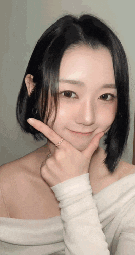 a woman wearing a white off the shoulder top is making a funny face