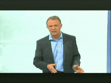 a man in a suit and blue shirt is giving a speech