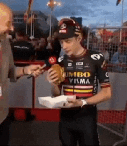 a man wearing a jumbo visma jersey is holding a hamburger