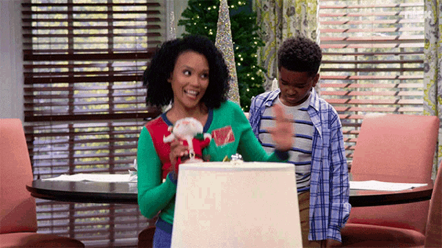 a woman in an ugly christmas sweater is holding a stuffed animal