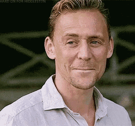 a close up of a man 's face wearing a white shirt and smiling .
