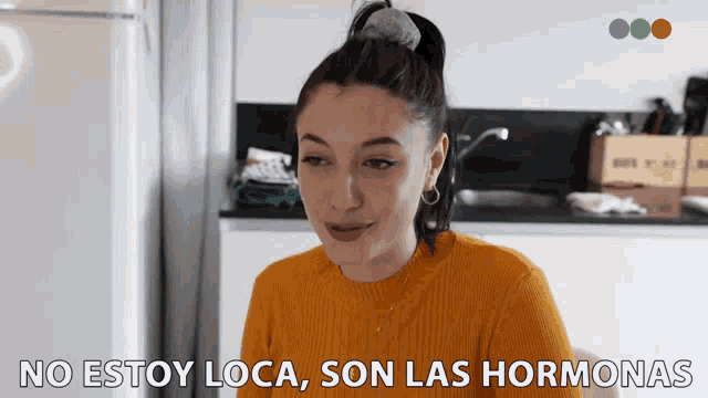 a woman says no estoy loca son las hormonas in a kitchen