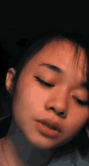 a close up of a woman 's face with her eyes closed .