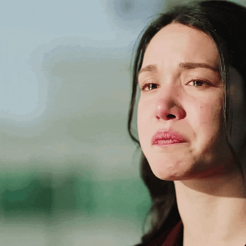 a close up of a woman 's face with a tear running down her cheek