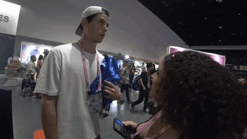 a man in a white shirt is talking to a woman in a pink bikini