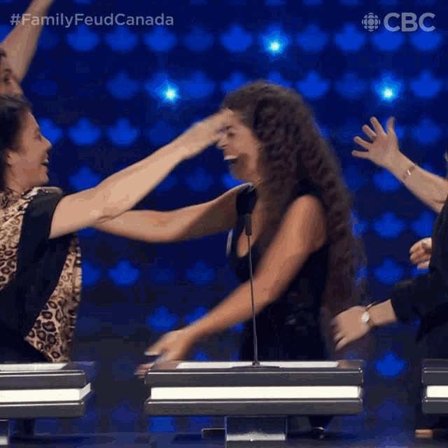 a group of women hugging each other in front of a screen that says cbc
