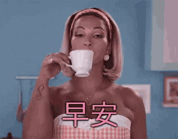 a woman is drinking a cup of coffee with chinese characters on her chest