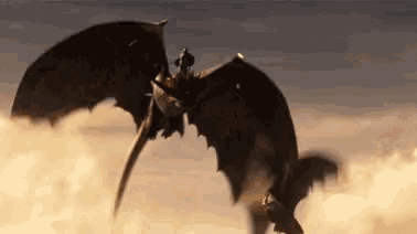 a dragon is flying through the air with a person riding on its back .