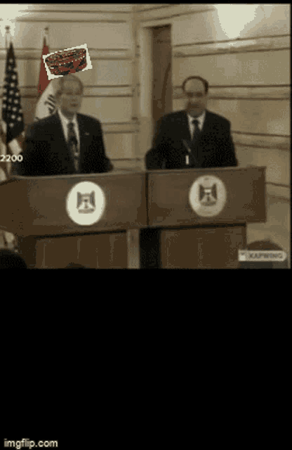 a man stands at a podium with a picture of a red car on his head