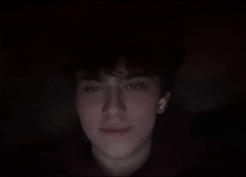 a close up of a person 's face with a dark background