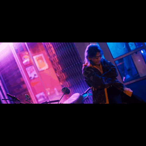 a woman standing in front of a motorcycle with a purple light behind her