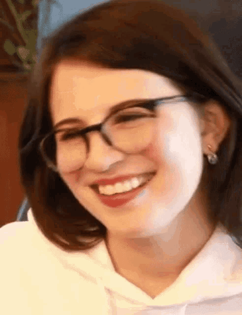 a close up of a woman wearing glasses and smiling .