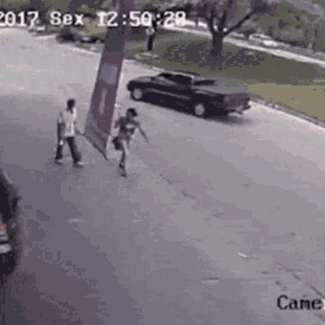 a couple of people are walking down a street in front of a truck .