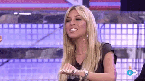 a woman with blonde hair and a black shirt is smiling on a tv show