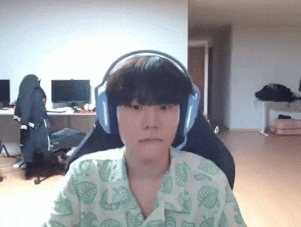 a young man wearing headphones and a pajama shirt is sitting in a chair in a living room .