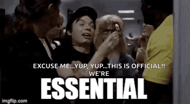 a group of people are standing around a sign that says ' essential ' on it