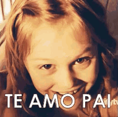 a little girl is smiling with the words te amo pai written above her