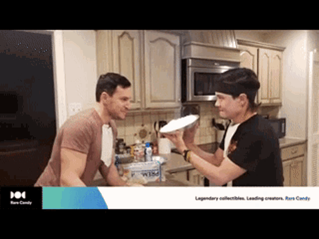 two men are standing in a kitchen and one is holding a plate that says brew on it