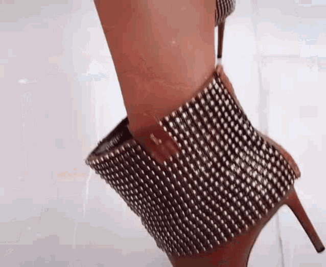 a close up of a woman 's foot wearing a pair of rhinestone heels .