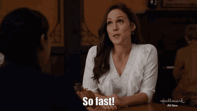 a woman sitting at a table with the words so fast written on the bottom