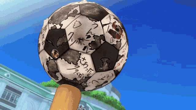 a soccer ball with chinese writing on it is on a pole