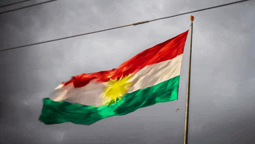 a kurdish flag is flying in the wind