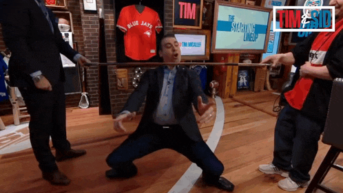 a man in a suit is kneeling down in front of a sign that says tim on it