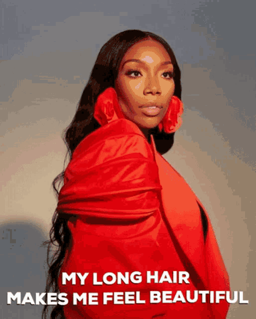 a woman with long hair wearing a red jacket and earrings